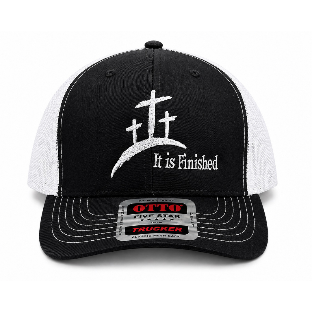 A black and white trucker cap featuring three white crosses on a hill with the text 'It is Finished' embroidered on the front. The brim has a silver metal size sticker for an Otto Five Star 5-7/8 trucker fit.
