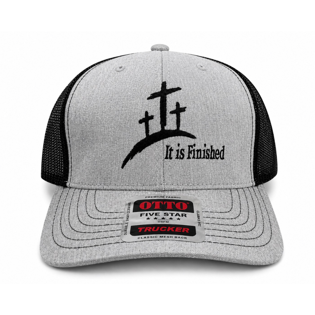 A heather gray and black trucker hat with a black embroidered cross graphic and the text 'It is Finished' on the front panel. The brim has a visible OTTO Five Star Trucker sticker.