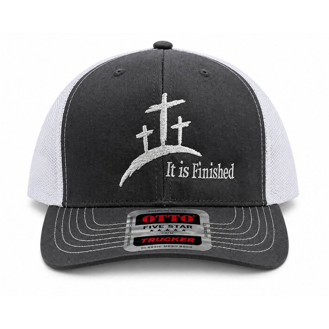 A dark gray and white trucker hat featuring a white embroidered cross design with the text 'It is Finished' on the front panel. The hat has a dark gray brim with white stitching and a visible 'Opto Five Star Classic Truck' sticker on the brim.
